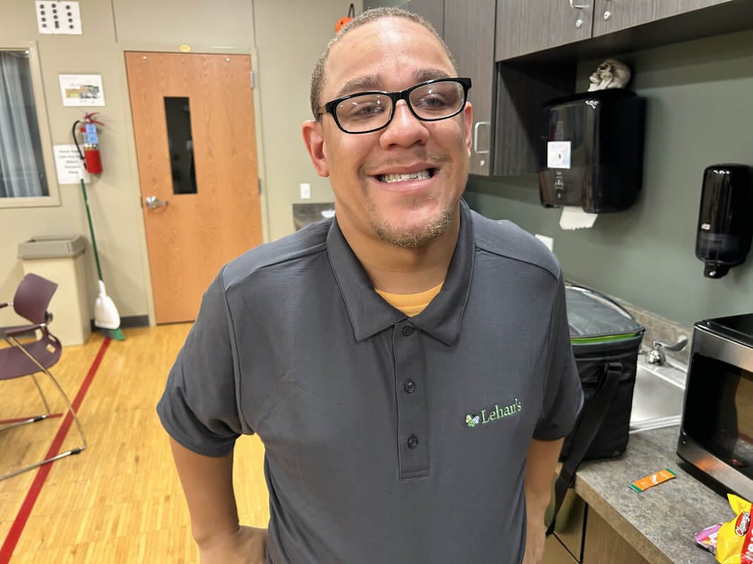 Opportunity House client smiling while on the job at a local business.