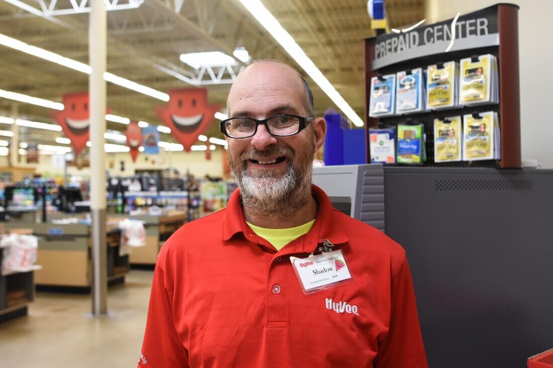 Opportunity House client smiling at the camera at their workplace.