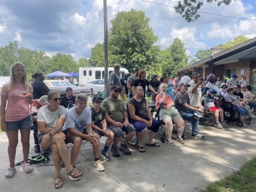Spectators sitting curbside at the Opportunity House Watermelon Explosion event.