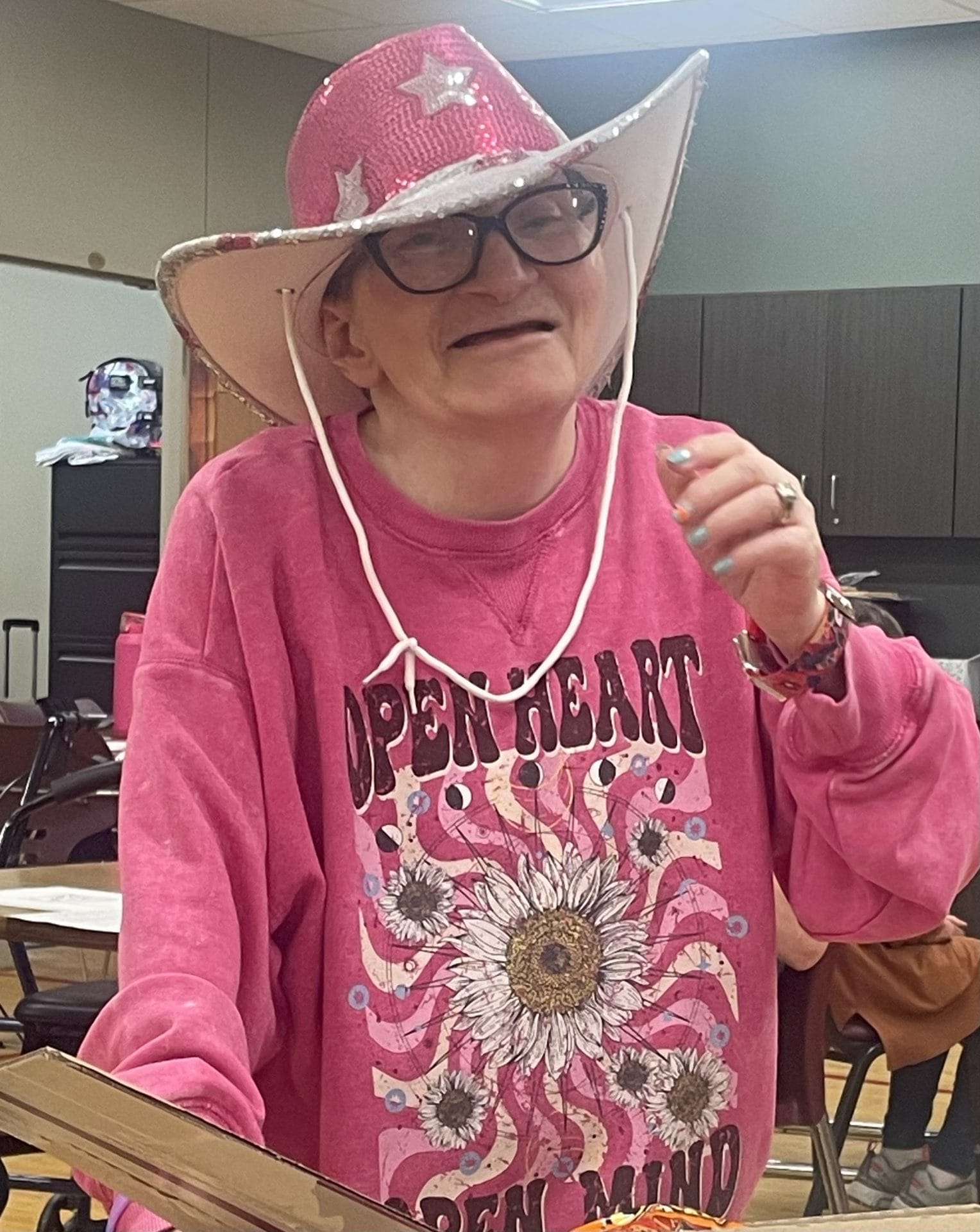 Opportunity House Recreation client smiling in a pink cowboy hat with silver stars.