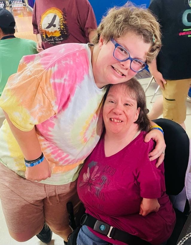 Two Opportunity House Recreation clients hugging.
