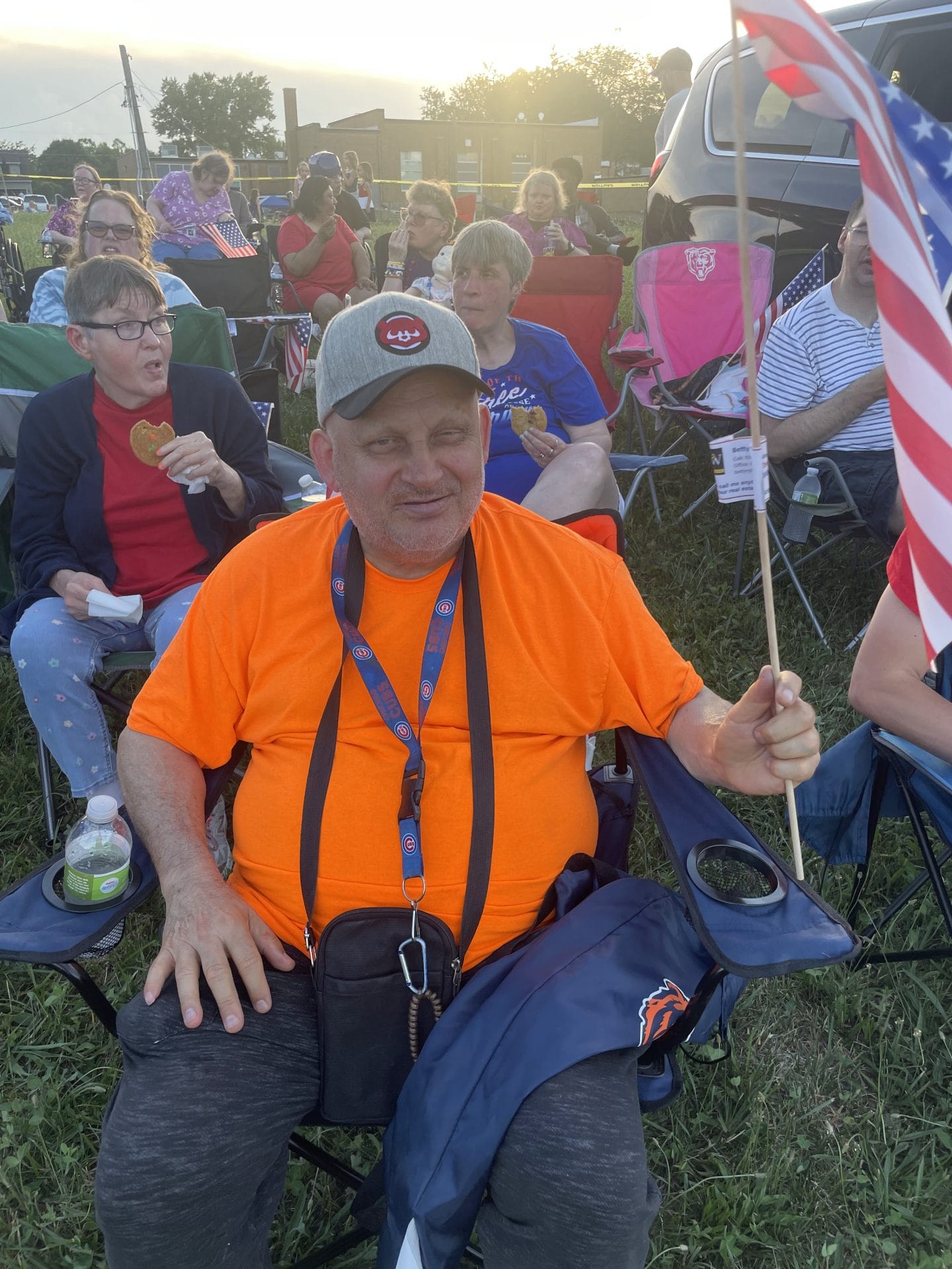Opportunity House Recreation client posing with American flag smiling at camera during a 4th of July festival.