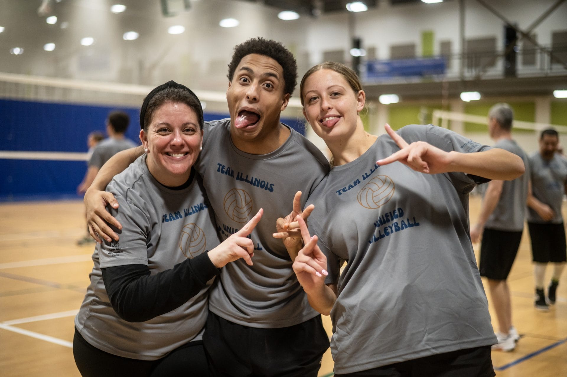 3 Special Olympics Illinois Volleyball Team members posing for photo.