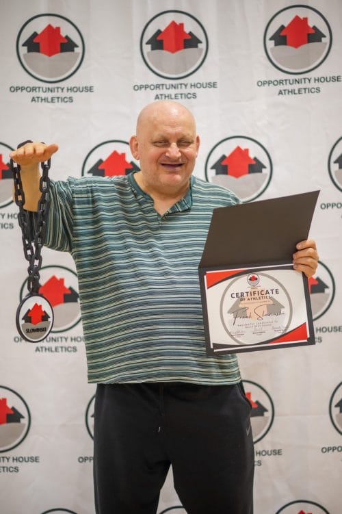 Opportunity House Athlete holding hype chain and Certificate of Athletics