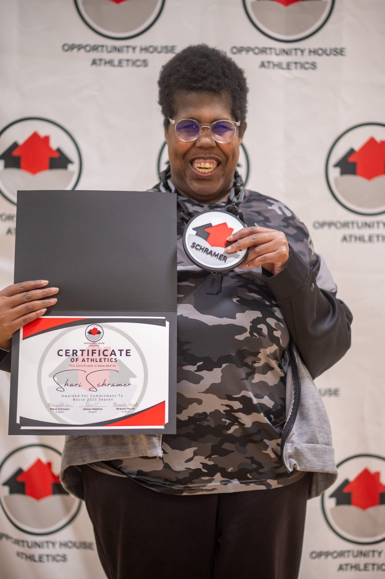 Opportunity House Athletics athlete holding hype chain and certificate