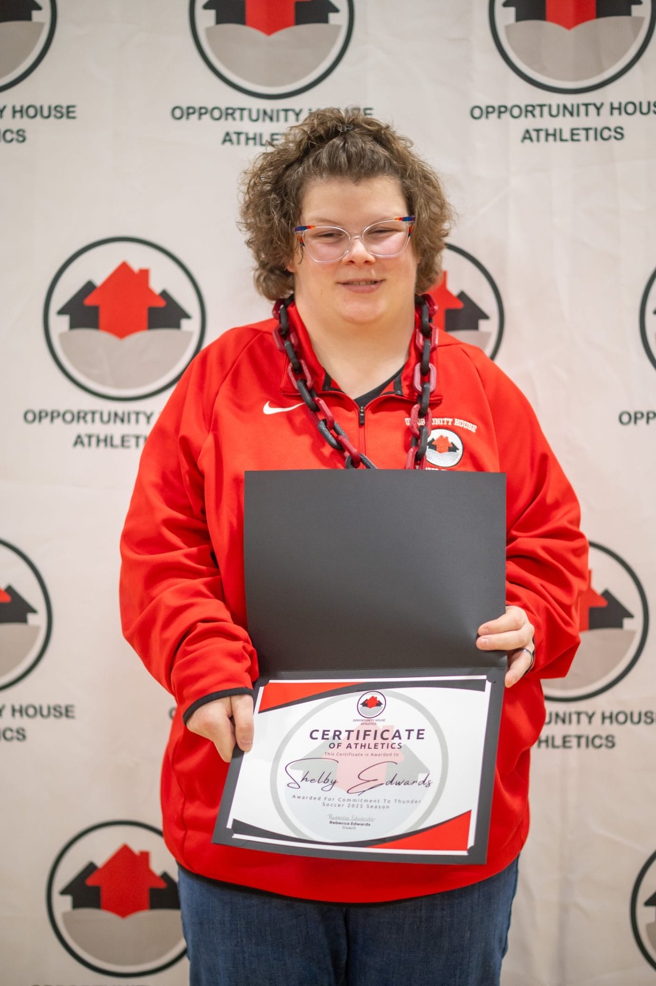 Opportunity House Athletics athlete holding certificate