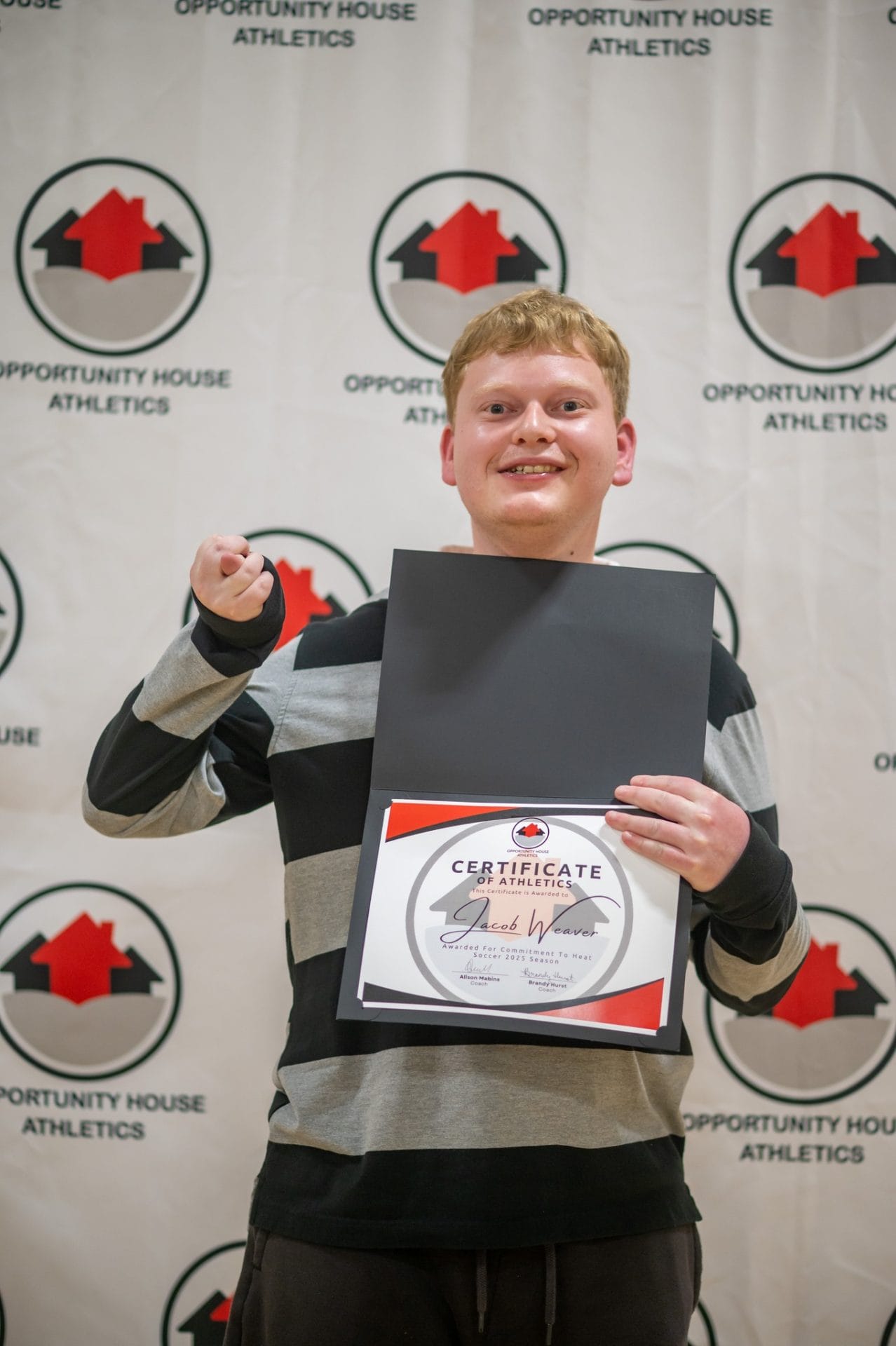 Opportunity House Athletics athlete holding certificate