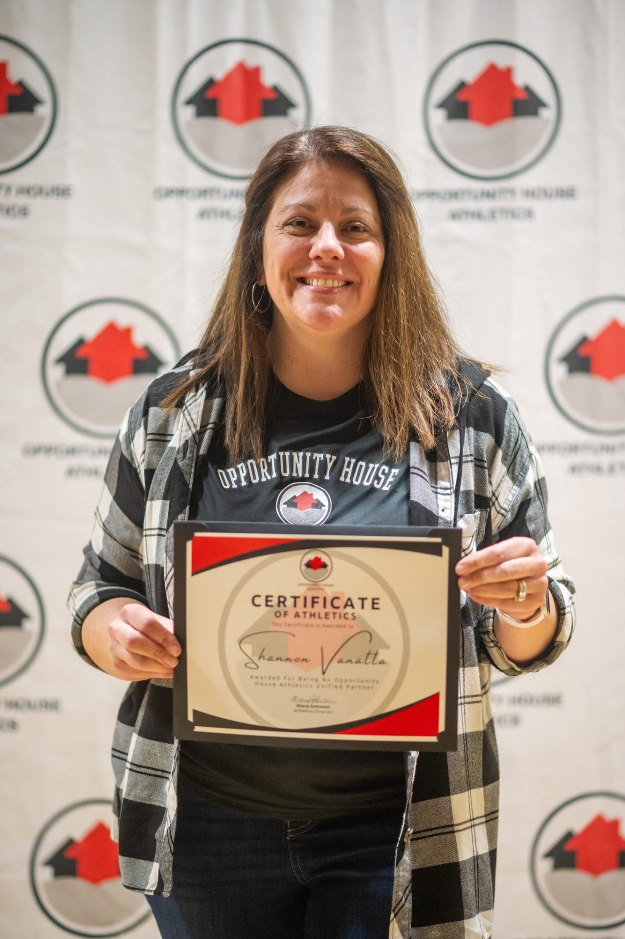 Opportunity House Athletics coach holding certificate