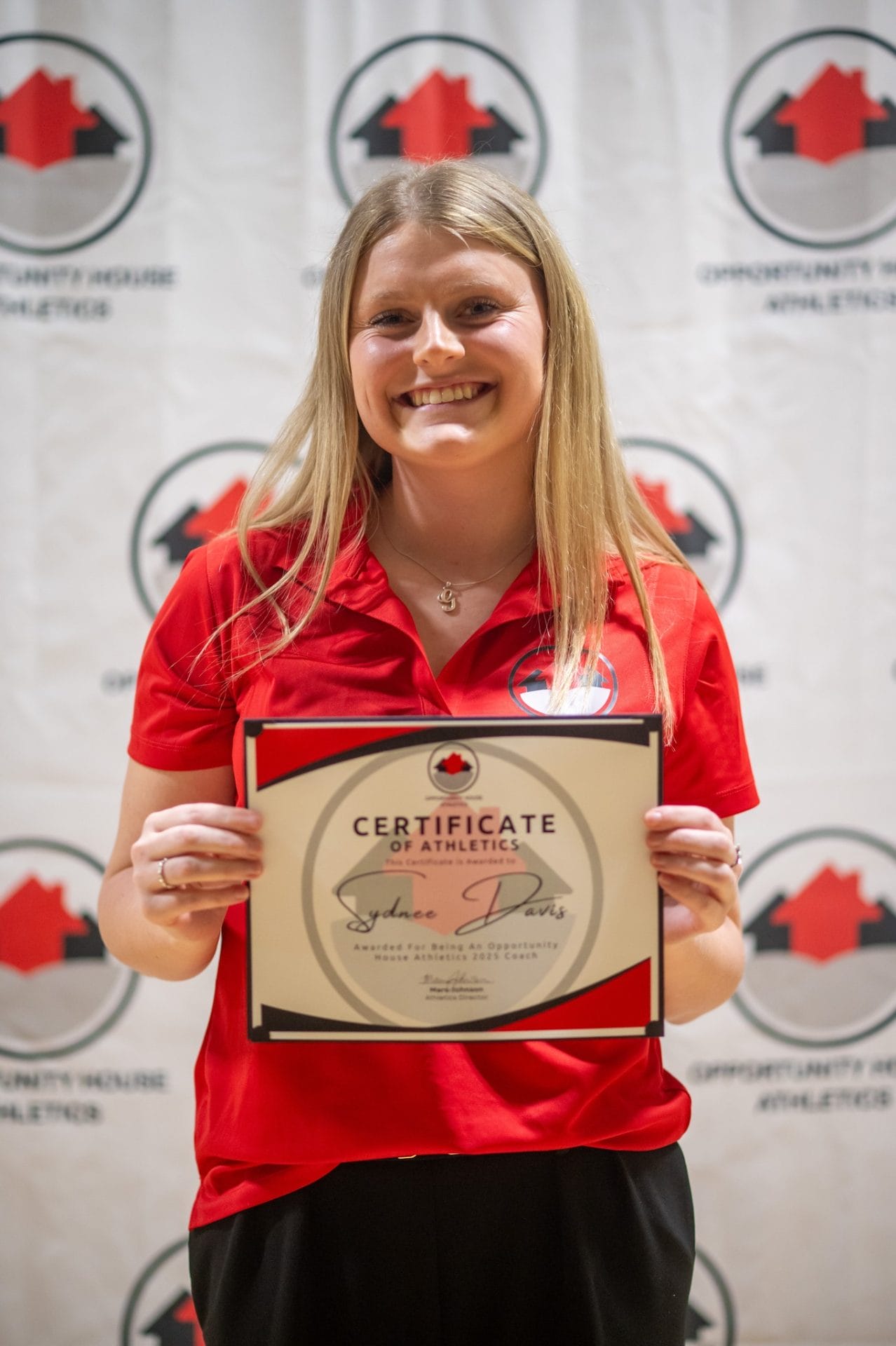 Opportunity House Athletics Coach holding certificate of athletics