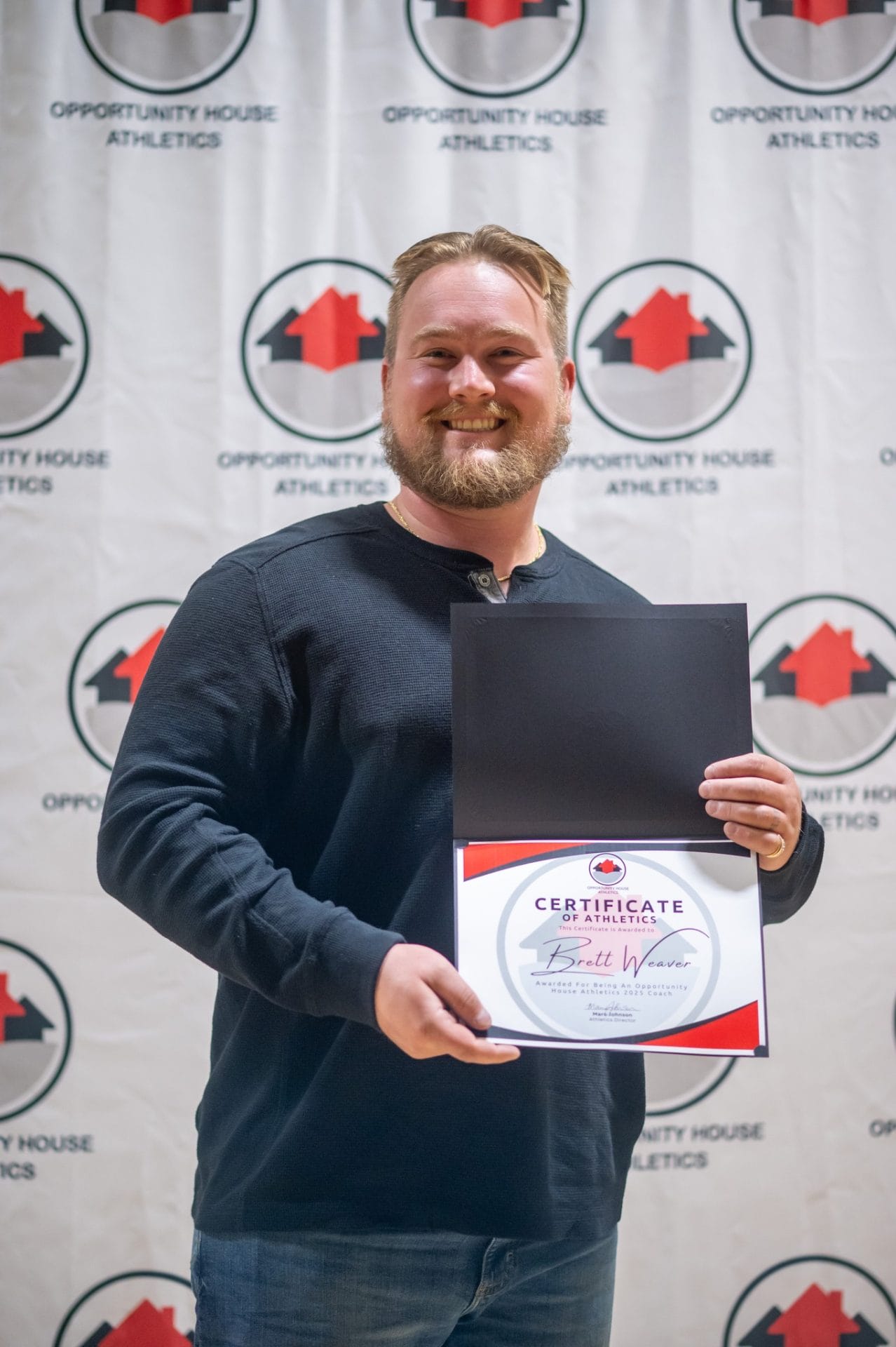 Opportunity House Athletics Coach holding certificate of athletics