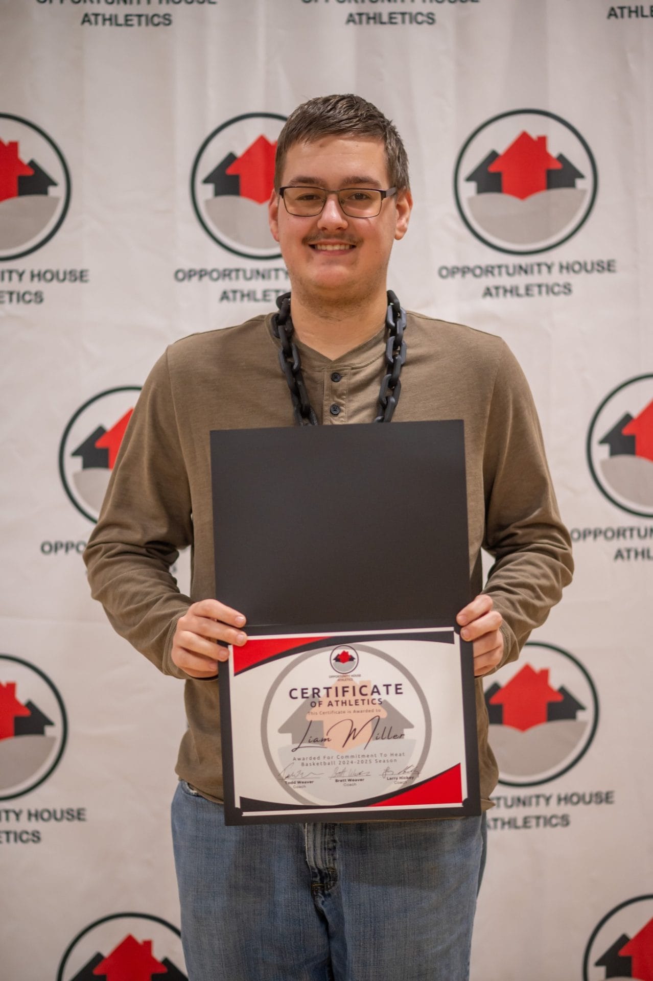 Opportunity House Athletics athlete holding certificate