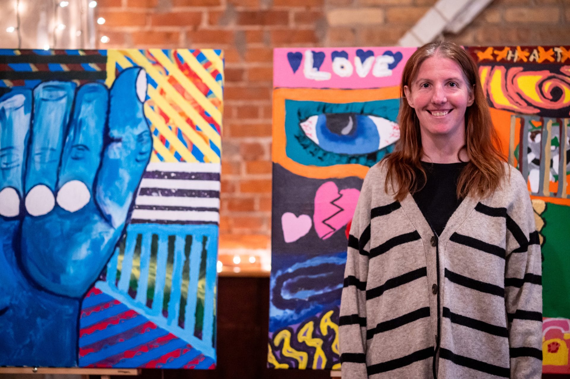 OH Client smiling in front of paintings.