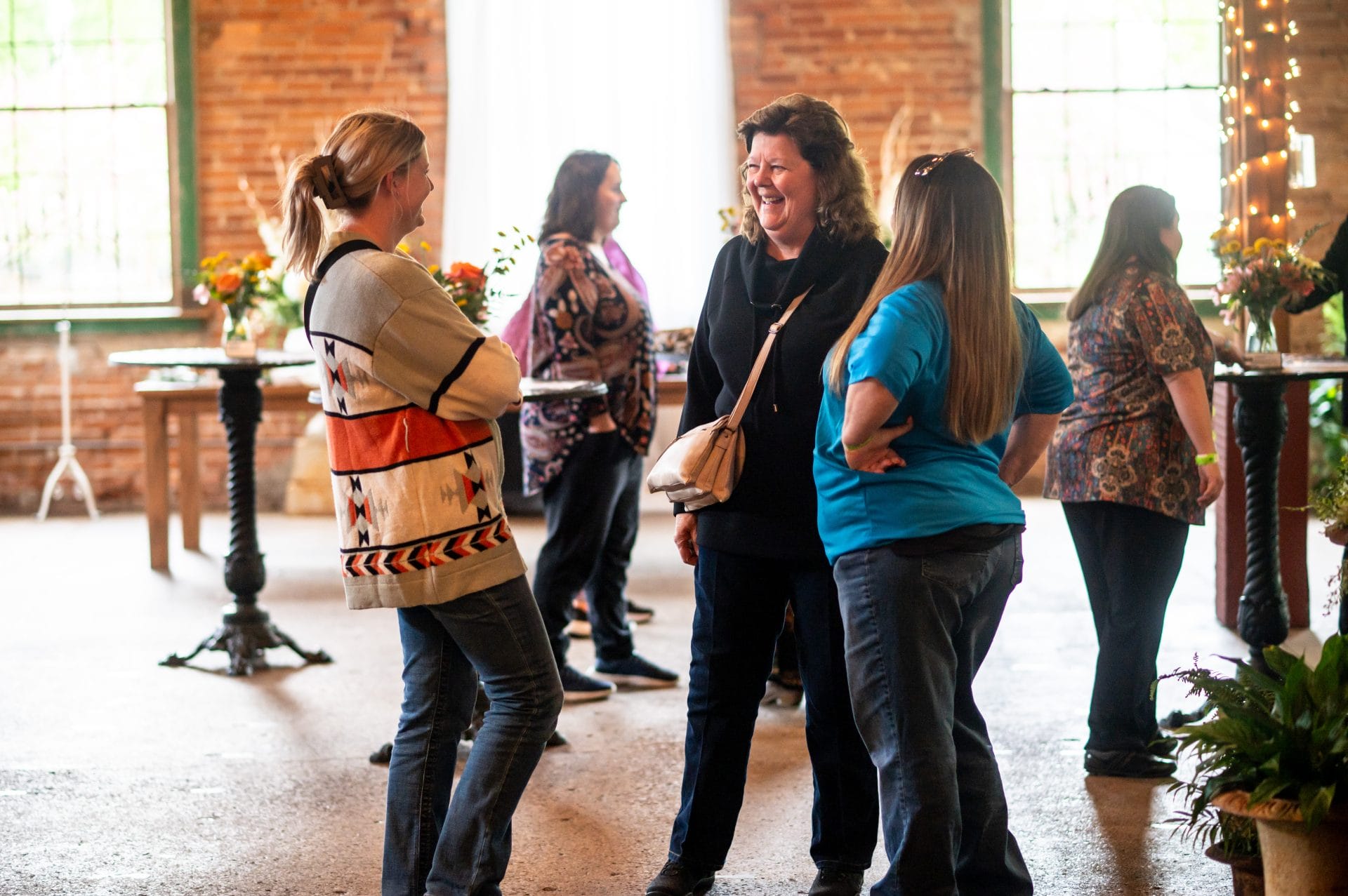 Two OH staff members chatting and laughing with Art Show Attendee.